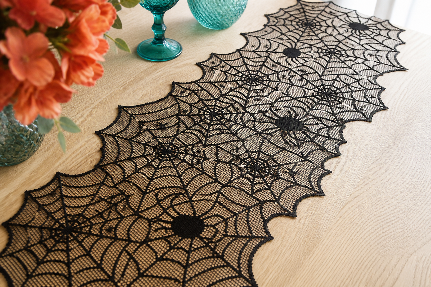 Close view of Webveil open black lace mesh scalloped web edges and spider motifs on a pale wood table