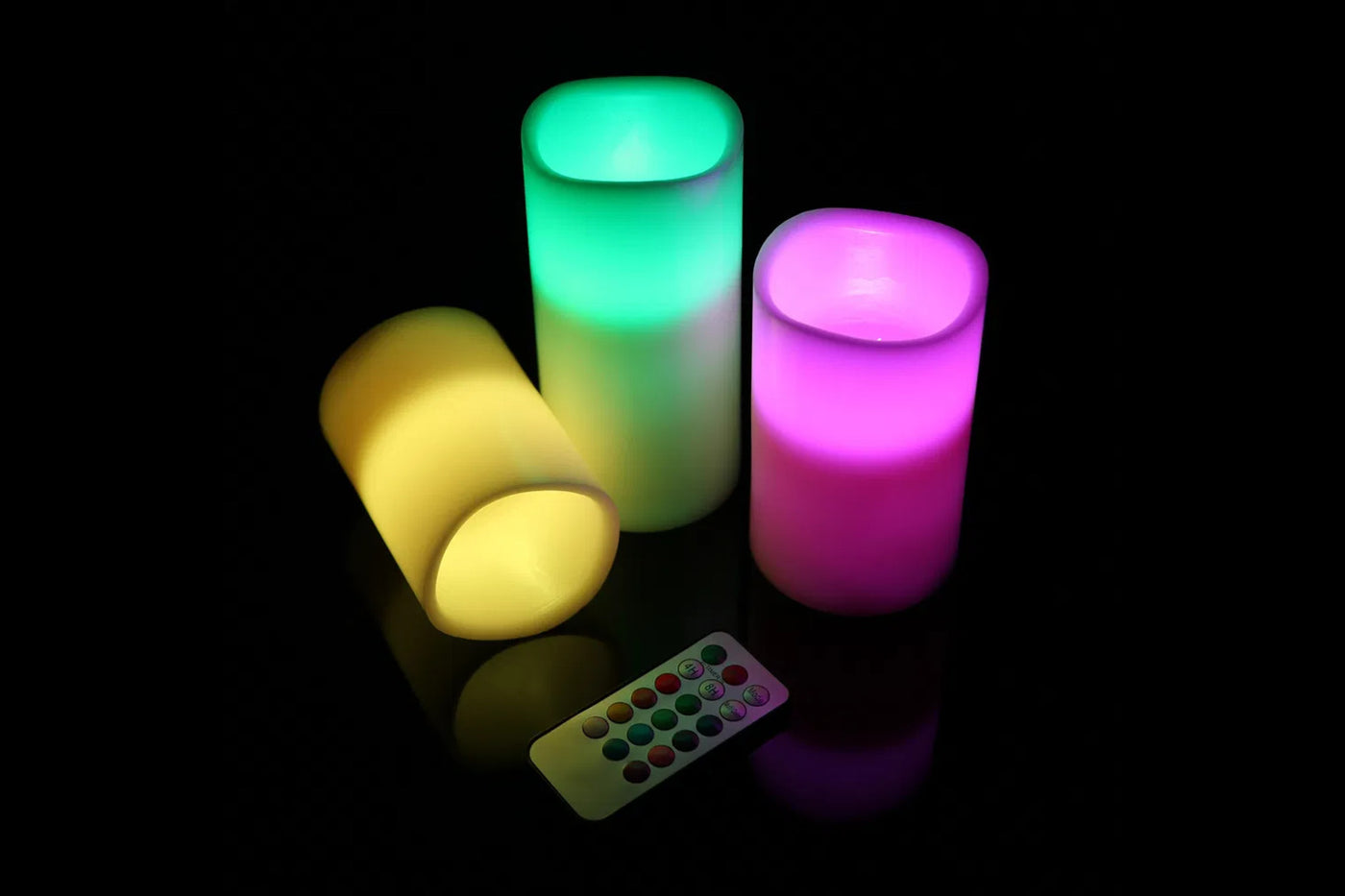 Exact Vesper candle set glowing in yellow, green, and magenta color modes with the remote