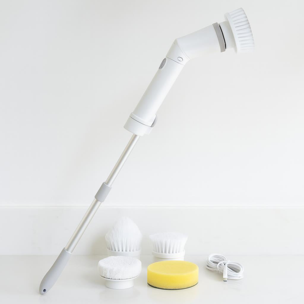 CleanReach spin scrubber standing upright on a bathroom counter beside its brush heads