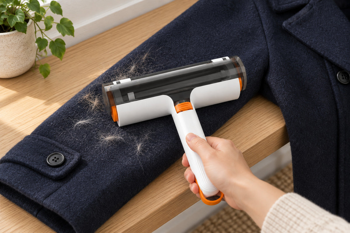 Hand using Furlift reusable pet-hair roller on a navy coat sleeve